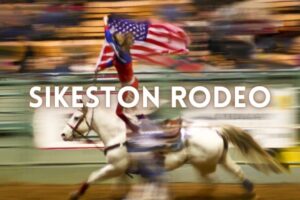 rodeo girl flying the American flag on horseback